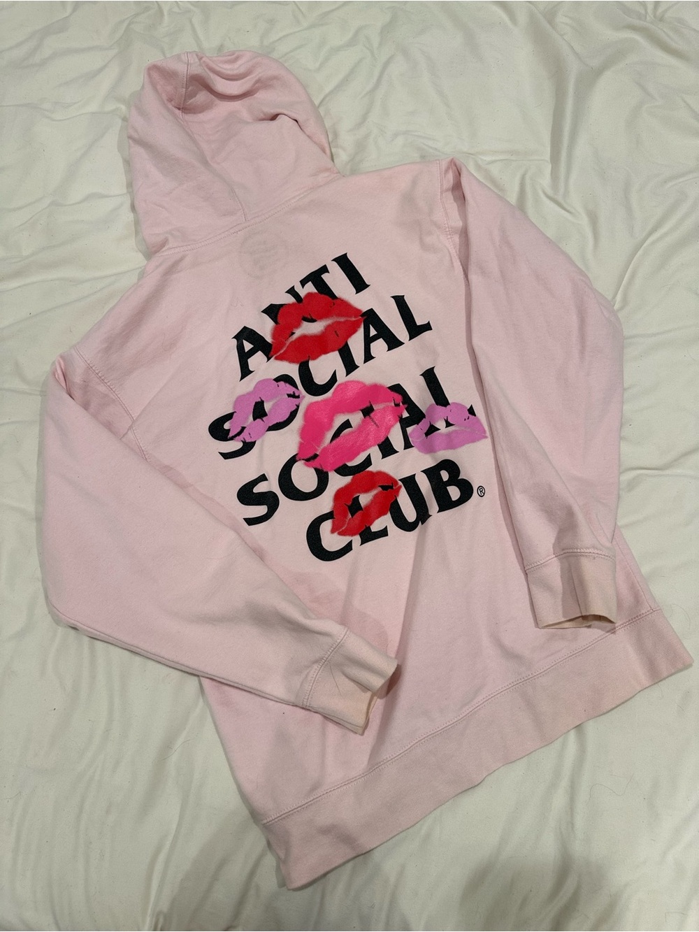 Pink Anti Social Social Club hoodie with black text and red/pink lips graphic